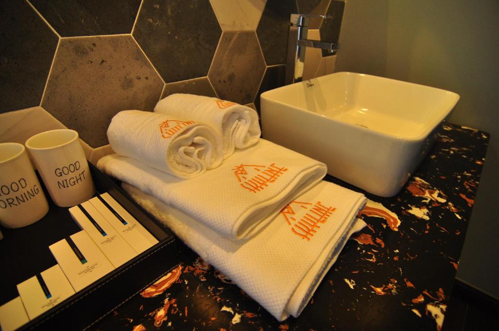 a bathroom with towels on a counter next to a sink at Saipan Skyline Designers Hotel in Saipan