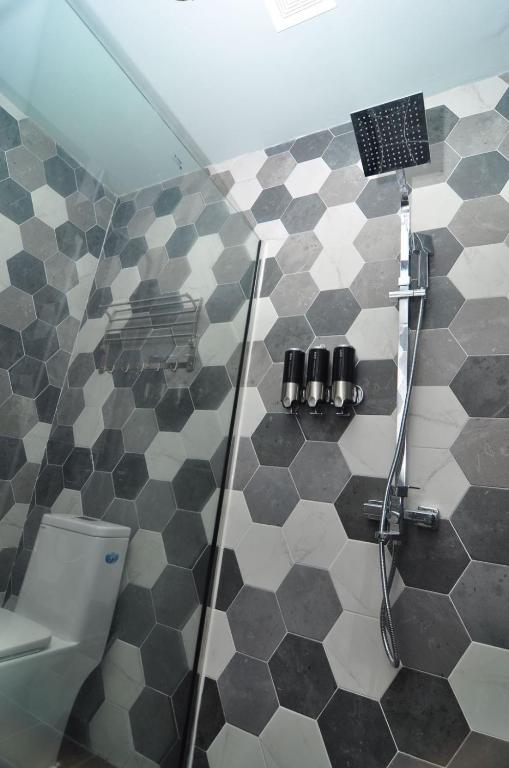 a bathroom with a shower with black and white tiles at Saipan Skyline Designers Hotel in Saipan