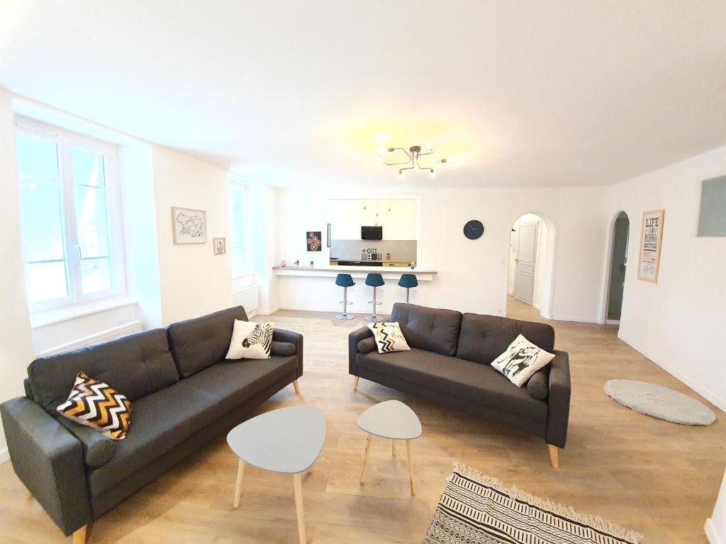 a living room with two couches and a table at Appartement de charme climatisé in Graulhet