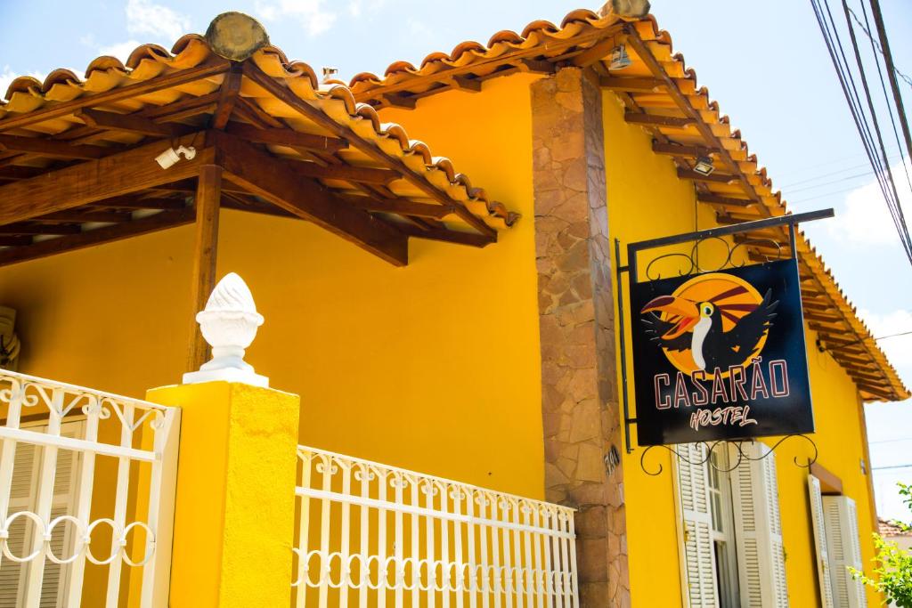 un edificio amarillo con un cartel. en Casarao Hostel - Analandia SP en Analândia