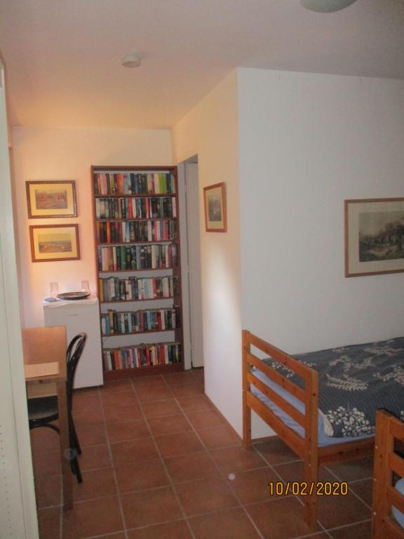 ein Schlafzimmer mit einem Bett und einem Bücherregal mit Büchern in der Unterkunft Maison d'hôtes Alsace - 4 chambres d'hôte - private Gästezimmer Elsass - private guest rooms Alsace in Bischwiller
