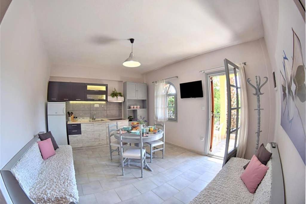 cocina y sala de estar con mesa y sillas en Calma Luxury Apartments #4 Sozopoli in Halkidiki, en Sozopoli