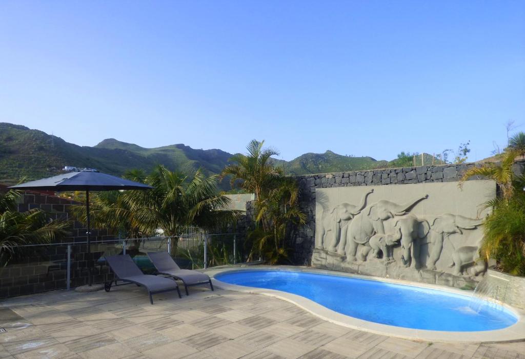 uma piscina com duas cadeiras e uma parede em Eco Suites Caves em San Cristóbal de La Laguna