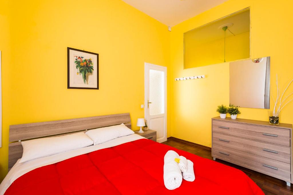 a bedroom with a red bed and yellow walls at Elly's House in Modena