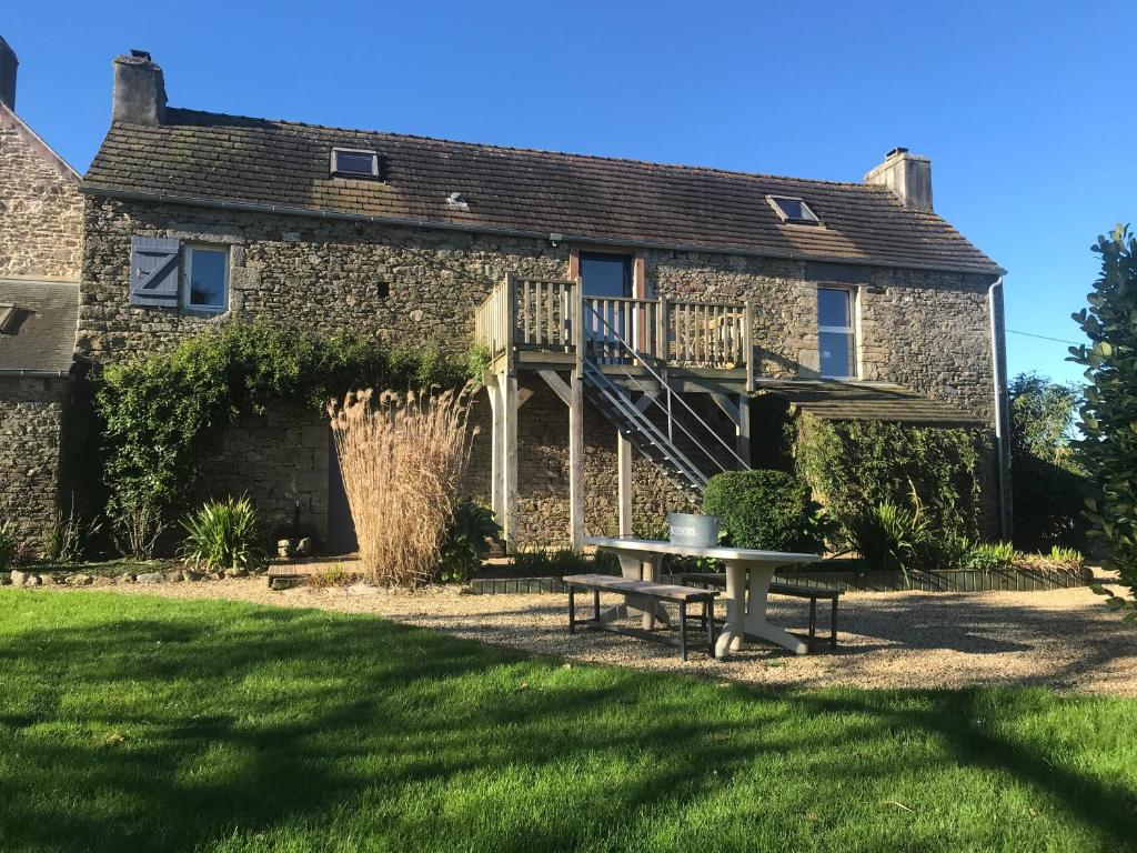 une maison en pierre avec une table de pique-nique dans la cour dans l'établissement GITE de charme entre Terre et Mer "Wifi et Netflix", à Plougonven