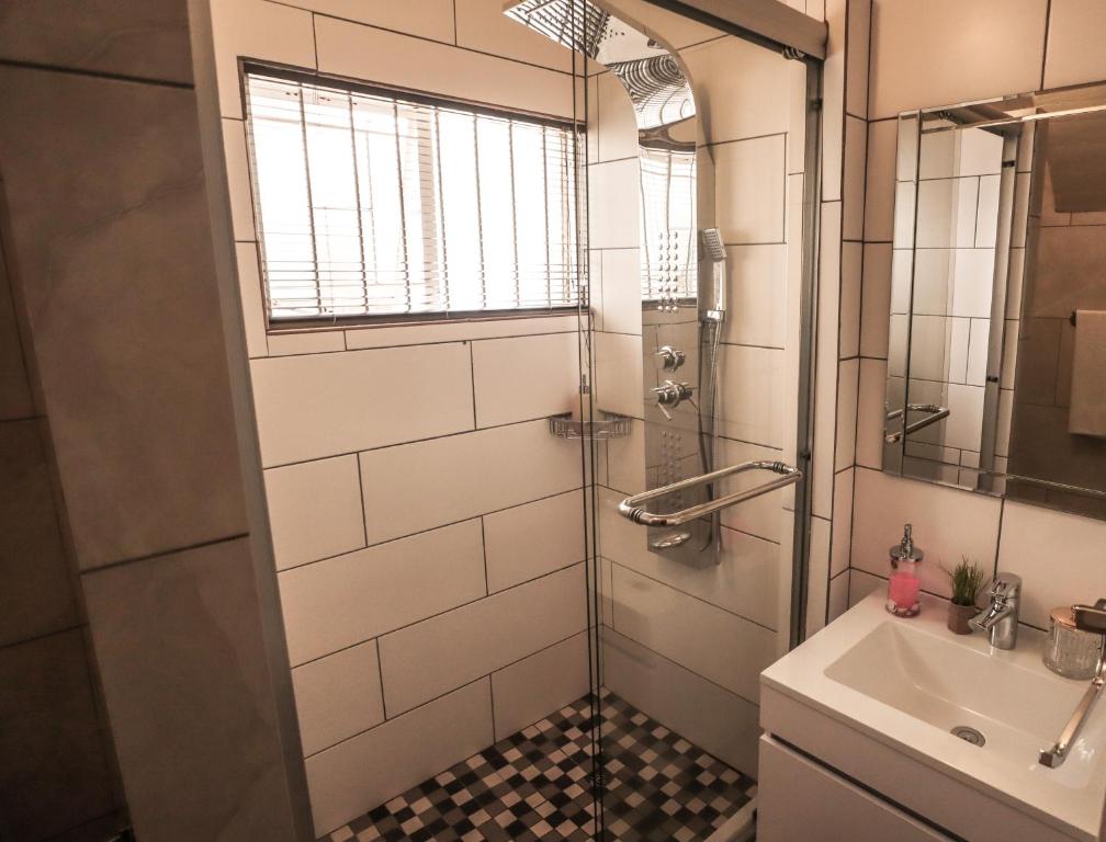 a bathroom with a shower and a sink at Menlyn Maine: The Exquisite Lunette in Pretoria