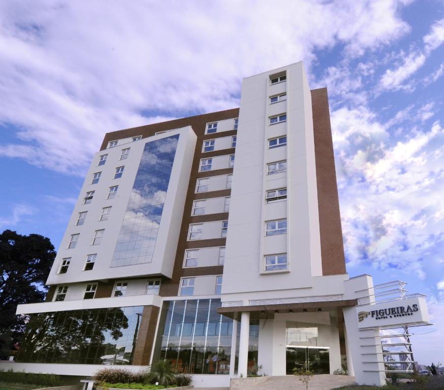 ein hohes weißes Gebäude mit einem Himmel im Hintergrund in der Unterkunft Figueiras Hotel & Eventos in São Miguel dʼOeste