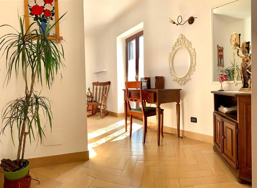 a living room with a desk and a table with a plant at Graziosa Camera privata vista mare in centro in Peschici