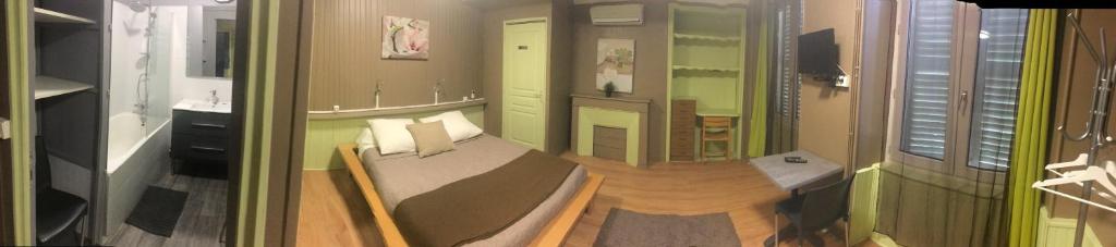 ein kleines Zimmer mit einem Bett und einem Spiegel in der Unterkunft L'Audycé in Lezoux