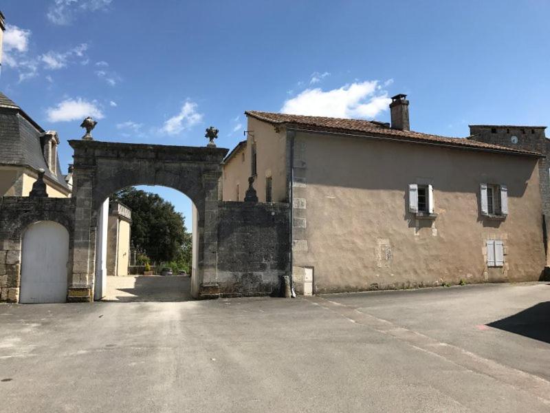 einen Eingang zu einem alten Gebäude mit Torbogen in der Unterkunft Le Milieu Chai, Chateau de Charras in Charras
