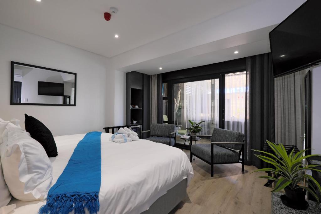 ケープタウンにあるPoint B Guest House -Sustainable Solar Energyのベッドルーム1室(青と白の毛布付きのベッド1台付)