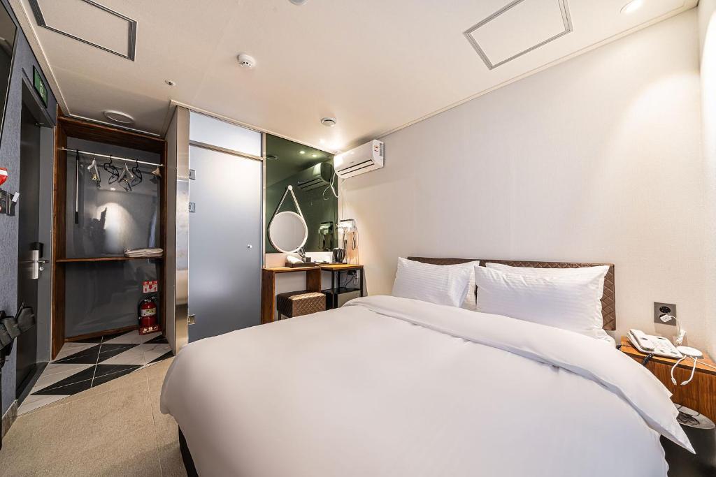 ein Schlafzimmer mit einem großen weißen Bett in einem Zimmer in der Unterkunft Hotel DDK in Seoul