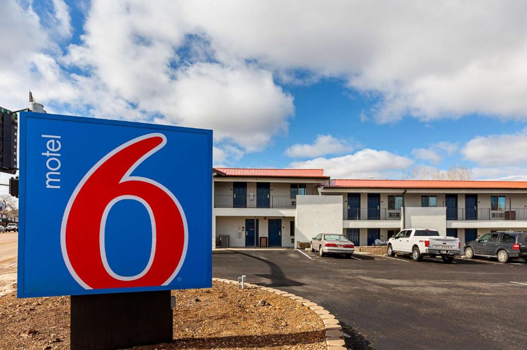 um sinal de limite de velocidade azul e vermelho em frente a um edifício em Motel 6-Show Low, AZ em Show Low