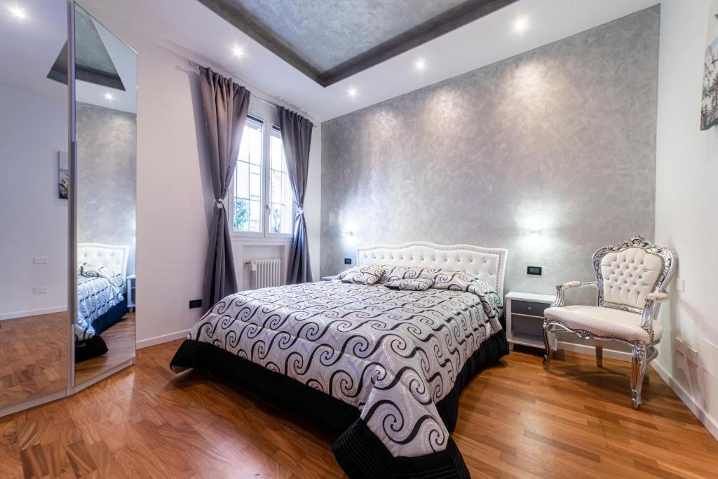 波隆那的住宿－FASHION APARTMENT SILVER Bologna，卧室配有床、椅子和窗户。