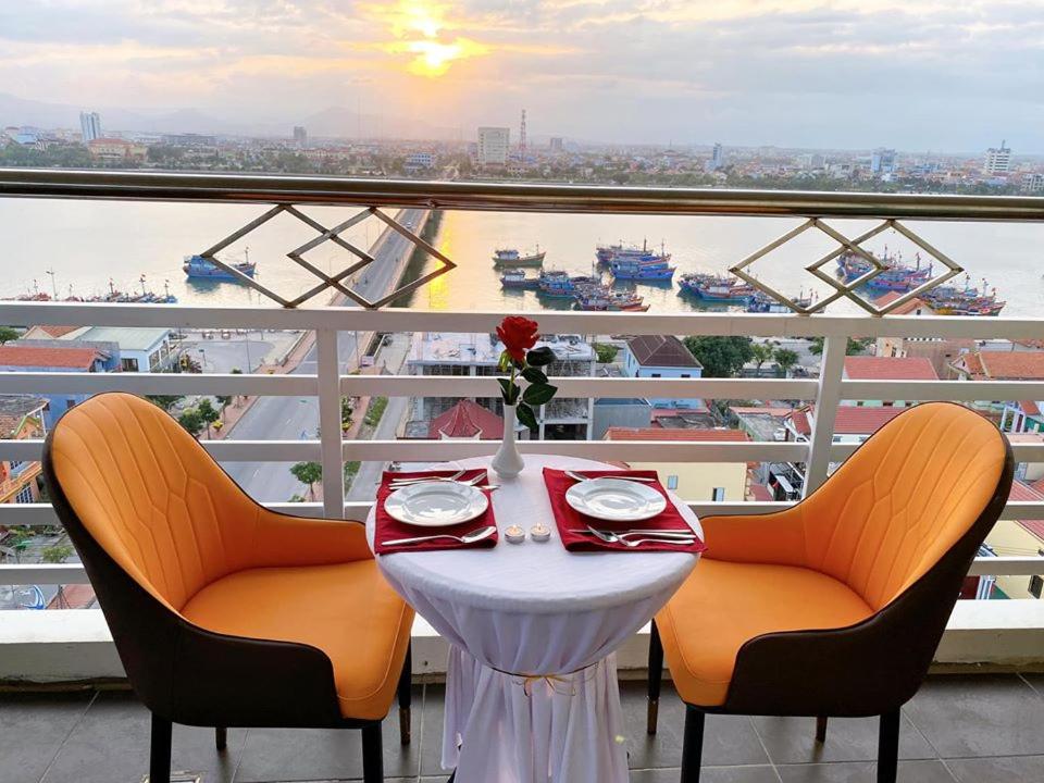 a table on a balcony with a view of a ship at Amanda Hotel in Dong Hoi