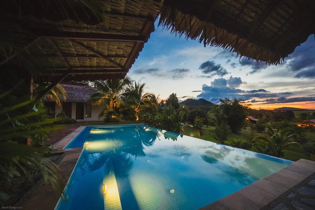 a swimming pool in a villa at sunset at Alamanda Villas Langkawi in Kuah