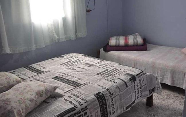 Zimmer mit 2 Betten und einem Fenster in der Unterkunft Pousada Alquidora in São Thomé das Letras