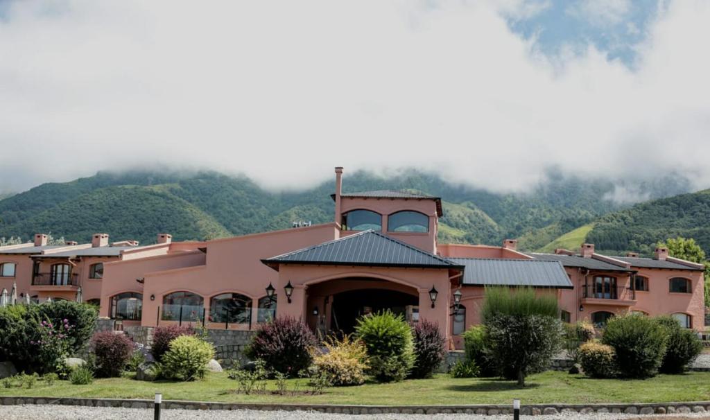 un edificio rosa con una montaña en el fondo en Mirador del Tafí en Tafí del Valle