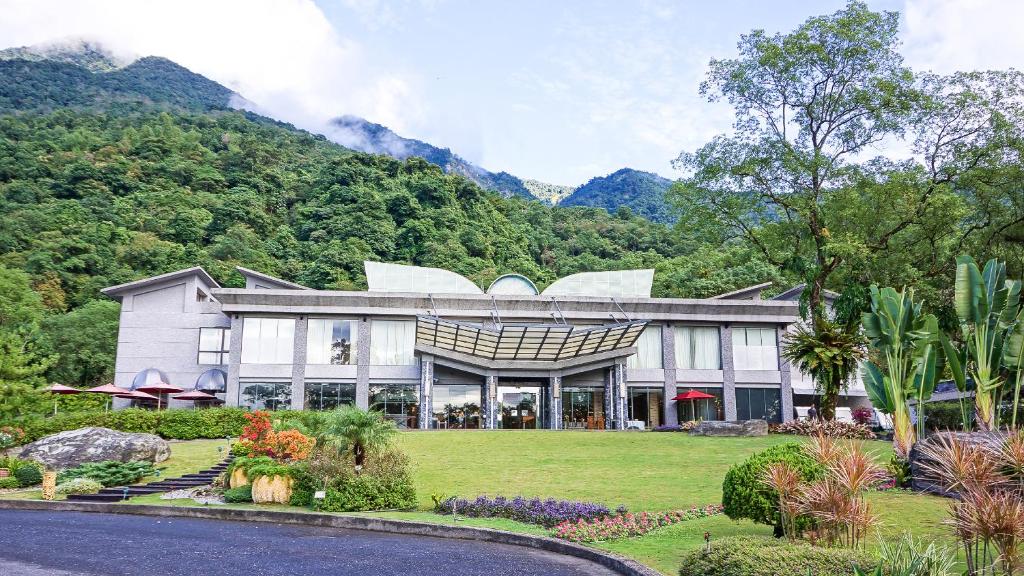 una casa con una montaña en el fondo en Butterfly Valley Resort, en Ruisui
