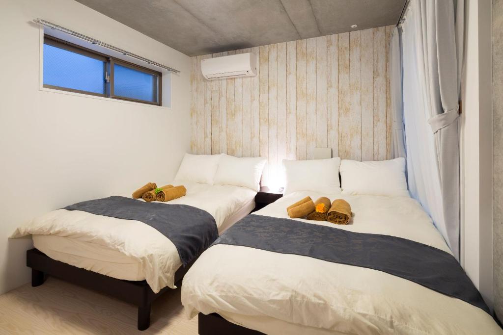 Postel nebo postele na pokoji v ubytování Laffitte Hirai Condominium Hotel
