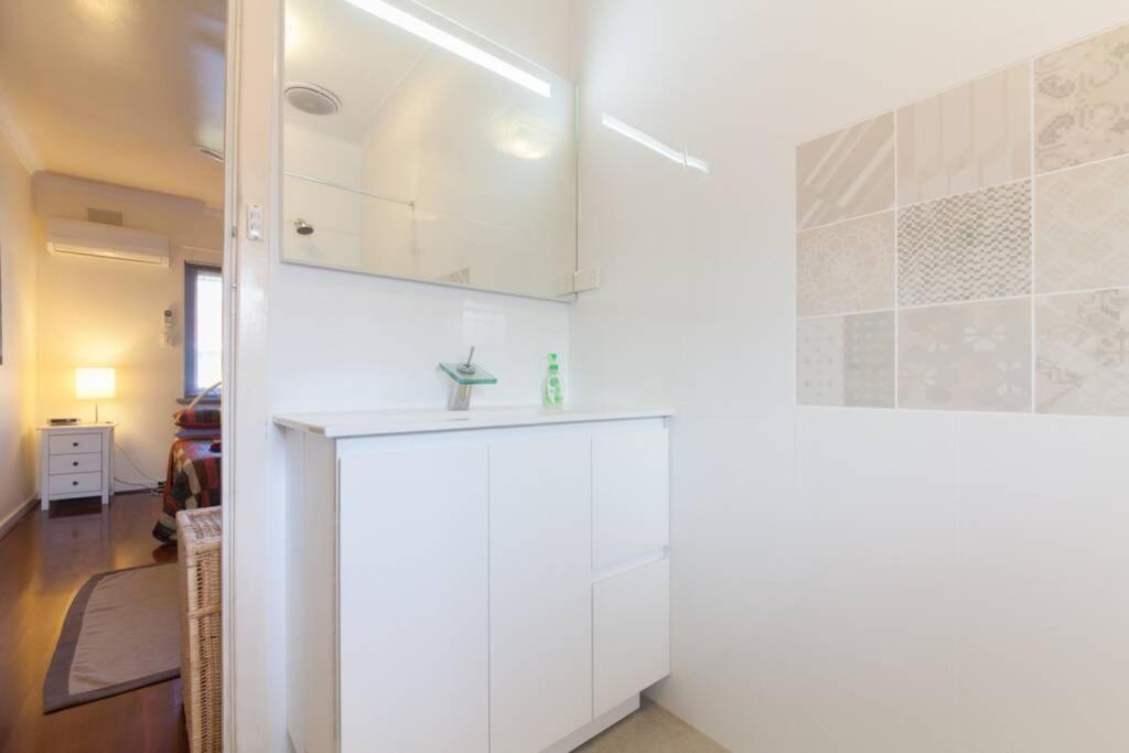 - une cuisine avec des placards blancs et un évier dans l'établissement B7 Crawley Apartment 1 BRM & Sleepout near UWA, à Perth