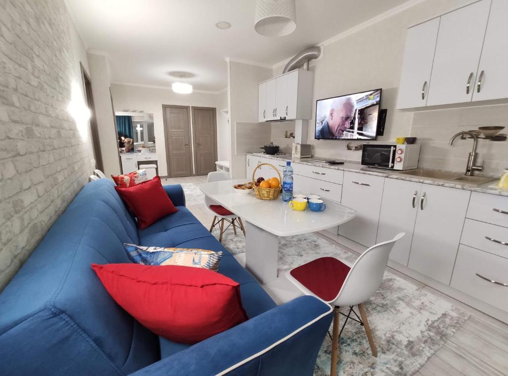 a living room with a blue couch and a white table at Lux Apartment Karakol Center in Karakol