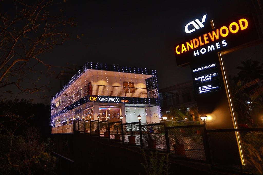 a building with a sign in front of it at night at CANDLE WOOD MUNNAR in Anachal