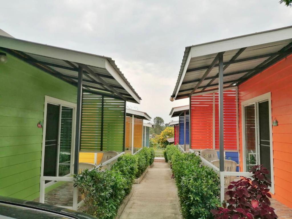 a row of colorful houses with a walkway between them at Sripech Home in Sangkhla Buri