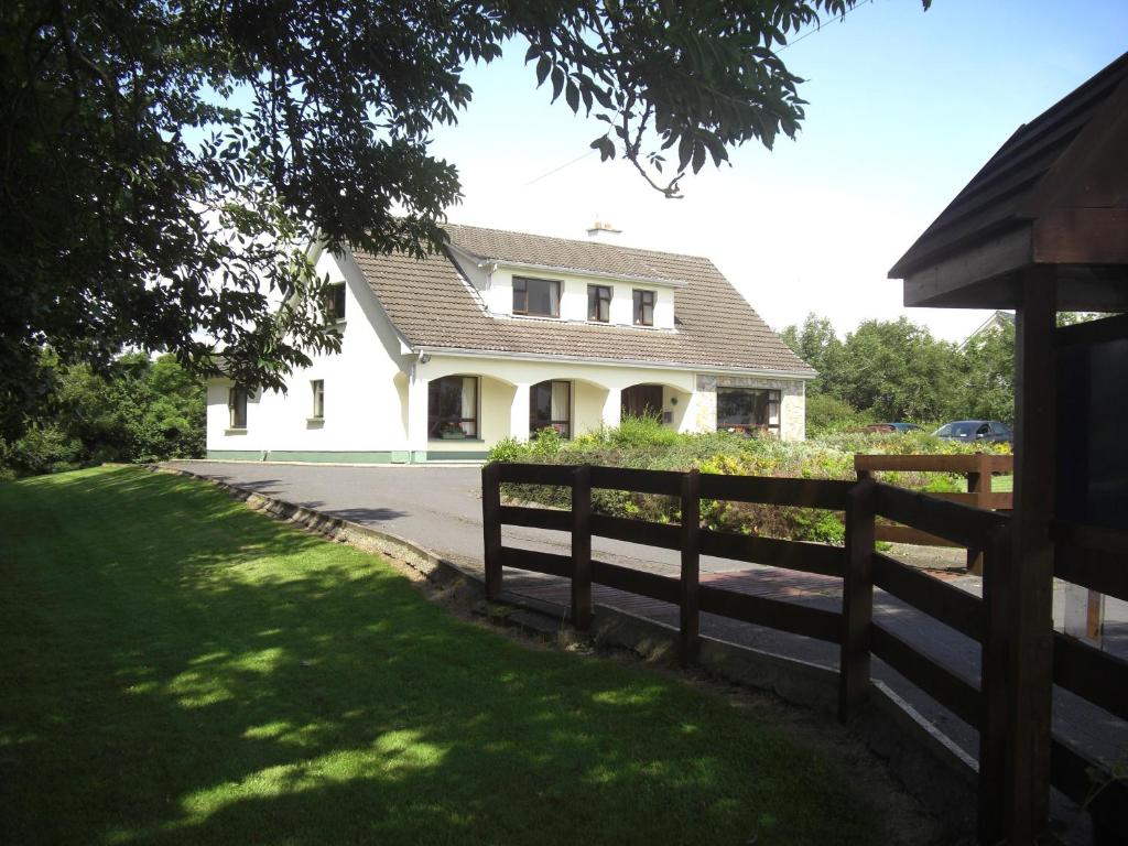 une maison blanche avec une clôture devant elle dans l'établissement Springlawn, à Clarinbridge