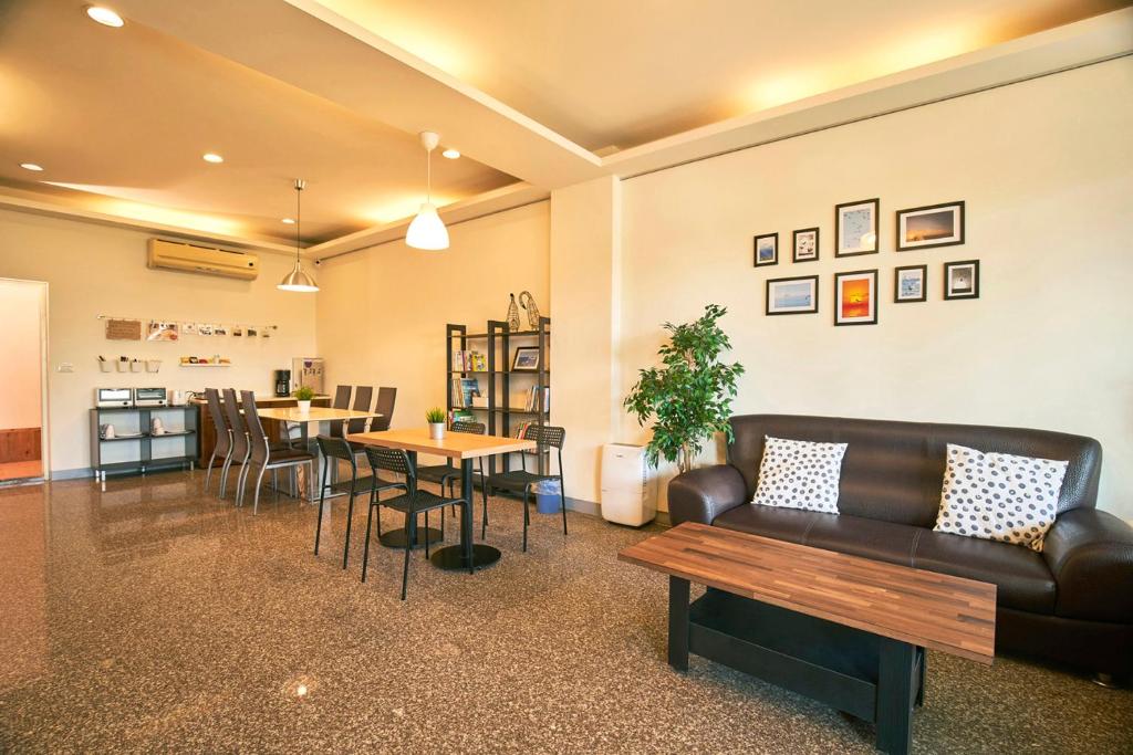 - un salon avec un canapé et une table dans l'établissement Migratory Birds Hotel, à Toucheng
