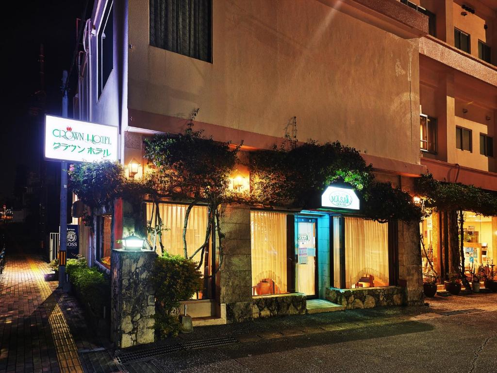 a building with plants on the side of it at night at Crown Hotel Okinawa in Okinawa City