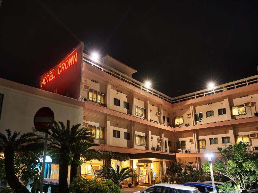 a hotel with a sign on the side of it at night at Crown Hotel Okinawa in Okinawa City