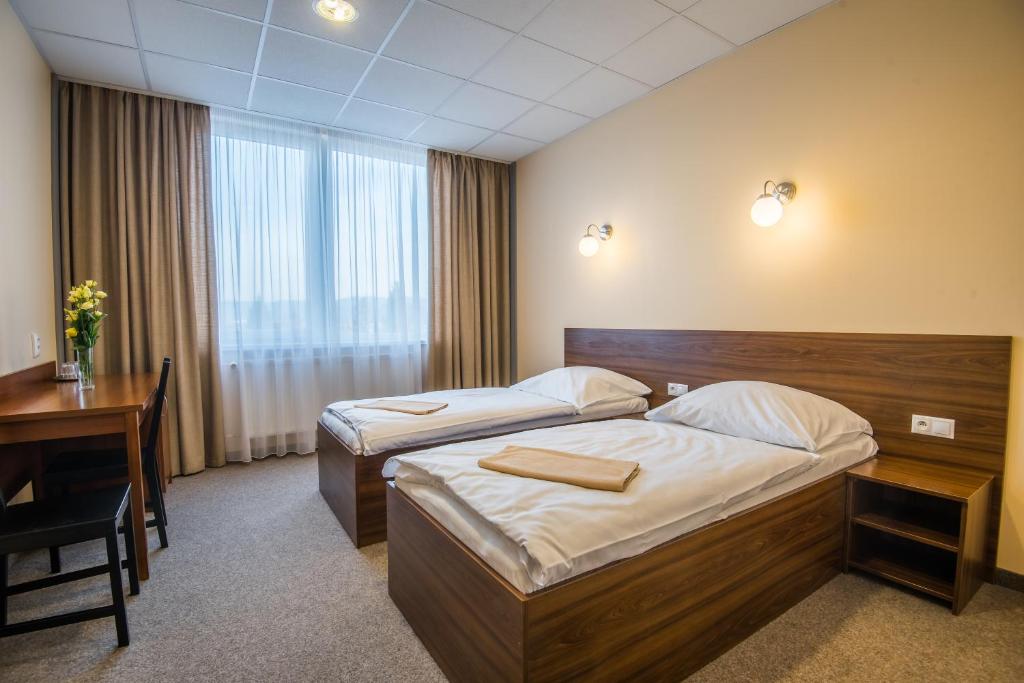 a hotel room with two beds and a desk at City Hotel B&B in Banská Bystrica