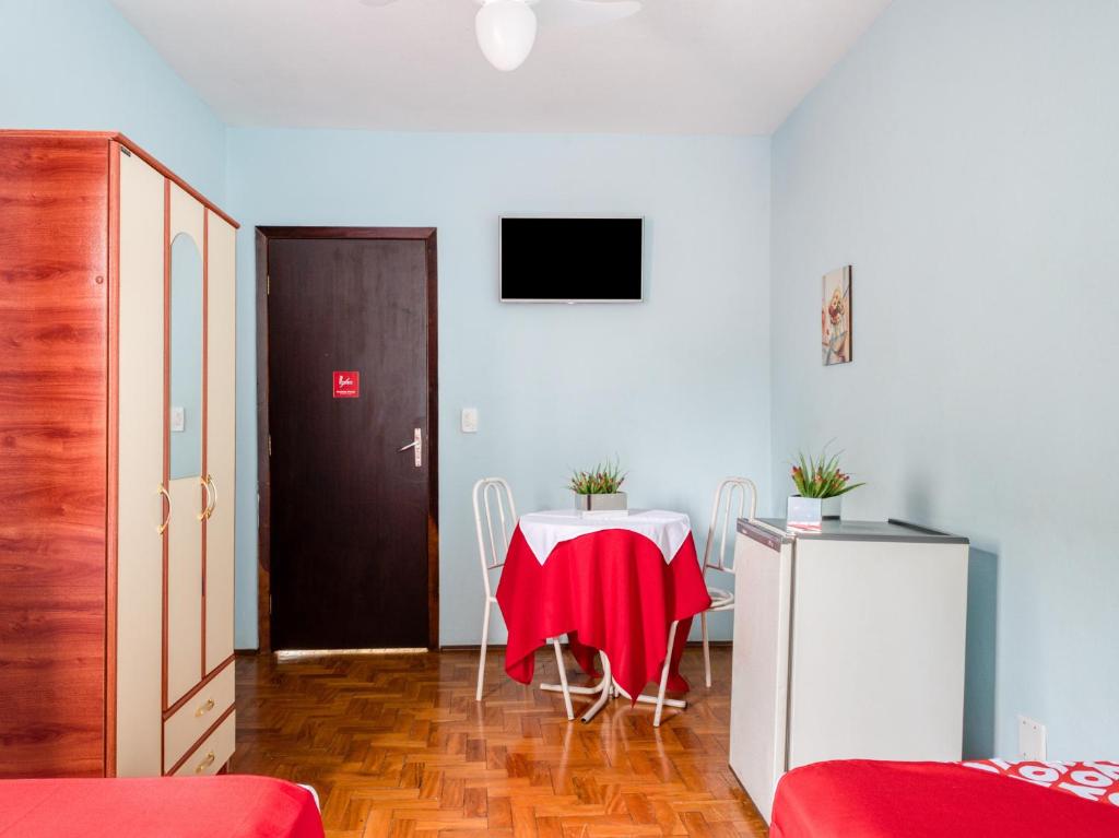 une chambre avec une table et un tissu de table rouge dans l'établissement Palace Hotel Itapira, à Itapira