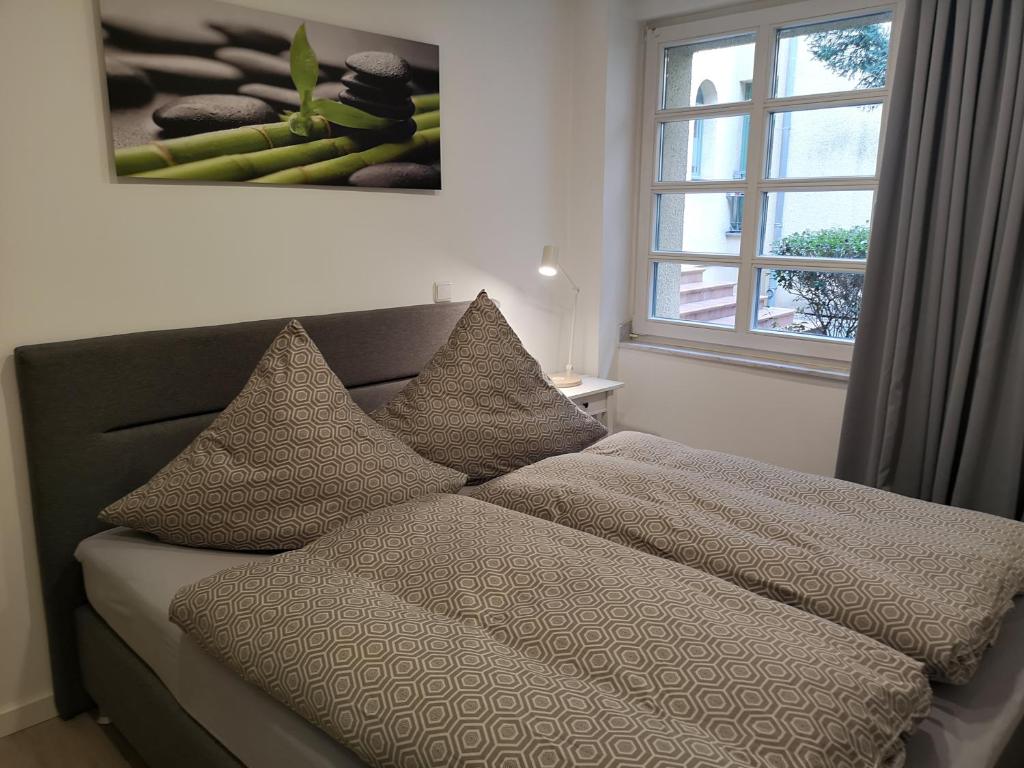 a bed with pillows and a window in a room at Apartment Potsdam in Potsdam