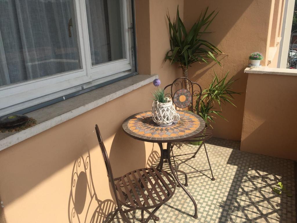 una mesa y sillas en un porche con ventana en Saint Peter Welcoming Apartment, en Roma