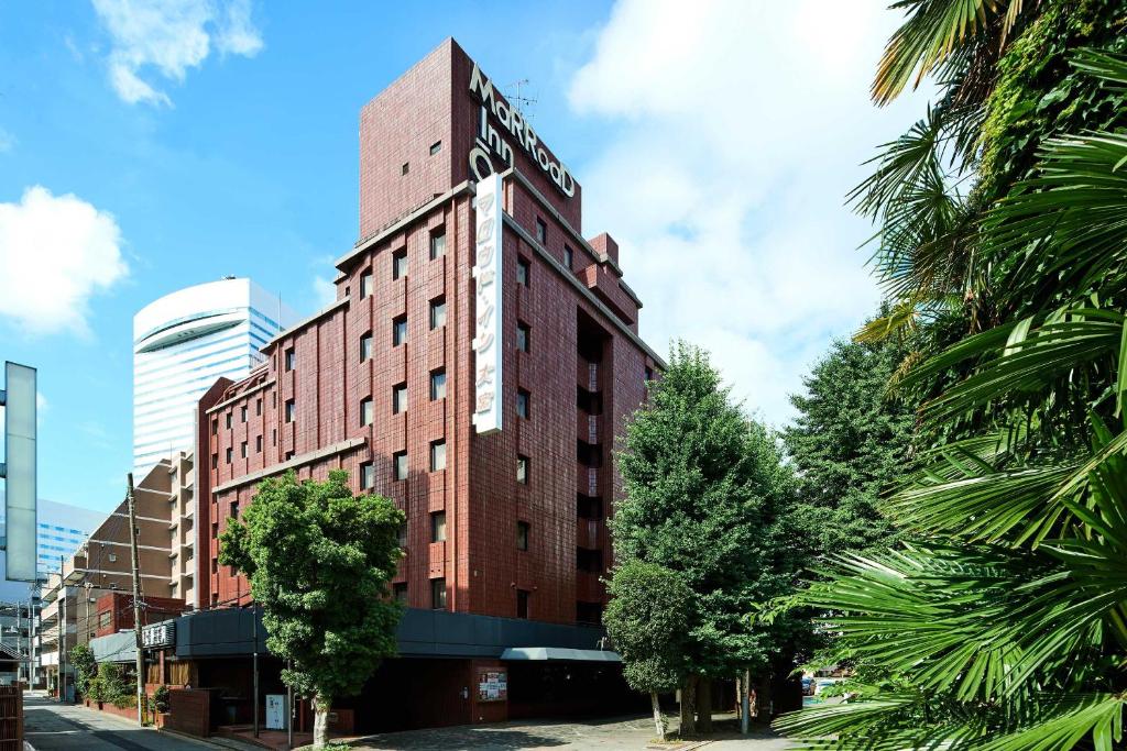 a tall red brick building with a sign on it at Marroad inn omiya in Saitama