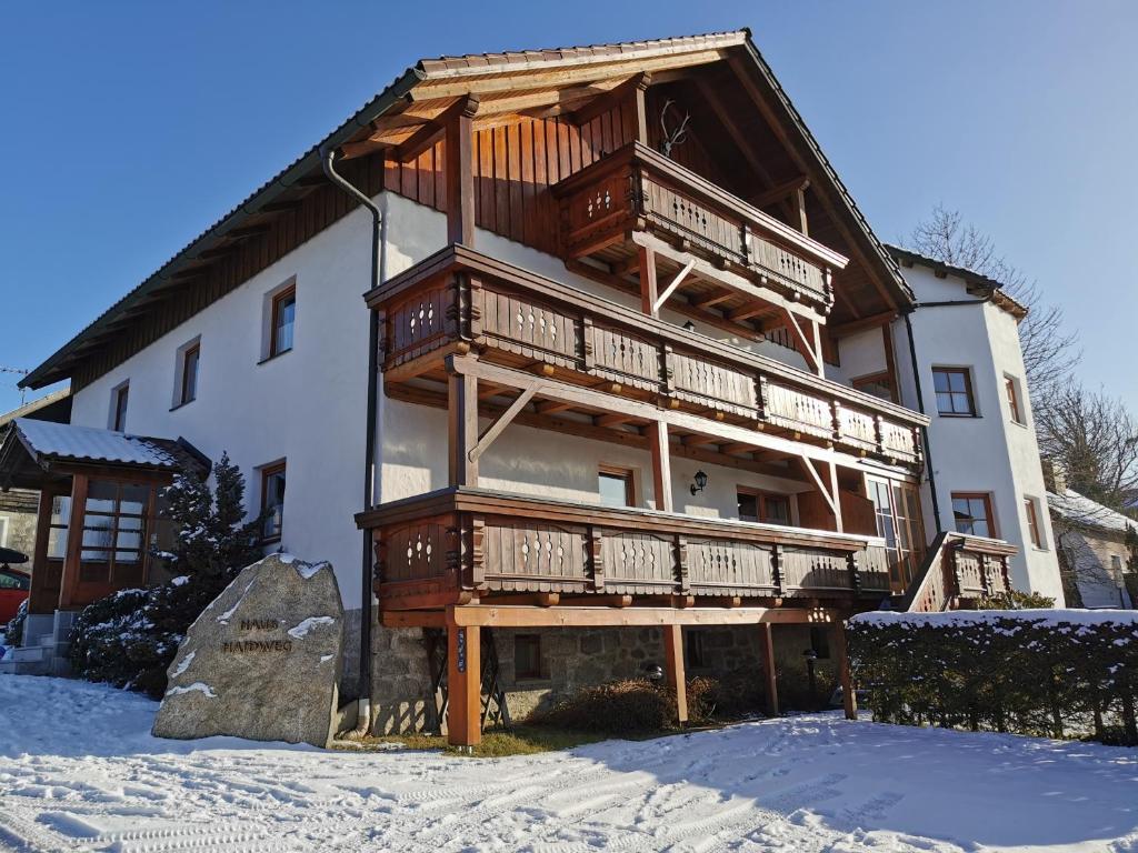 a large building with wooden balconies in the snow at Haus Haidweg - Ferienwohnungen in Haidmühle im Dreiländereck DE-CZ-AT in Haidmühle