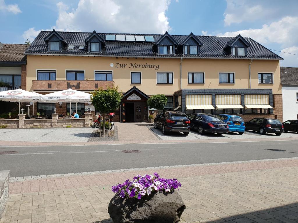 un edificio con una maceta a un lado de la calle en Hotel Restaurant Zur Neroburg en Neroth
