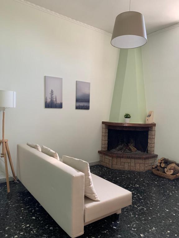 a living room with a white couch and a fireplace at BnB Nonna Maria in Poggiomarino