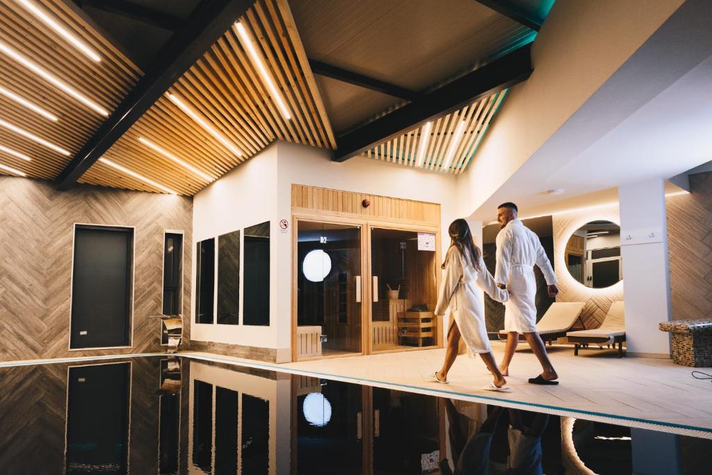 a couple walking through a house at Hotel Tiski Cvet in Novi Bečej