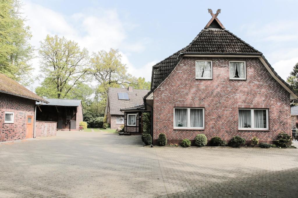 an old brick house with a gambrel roof at Ferienwohnungen Eichenhof in Schneverdingen