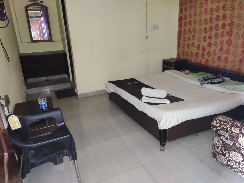 a small bedroom with a bed and a chair at Hotel Blue Star in Haldwāni