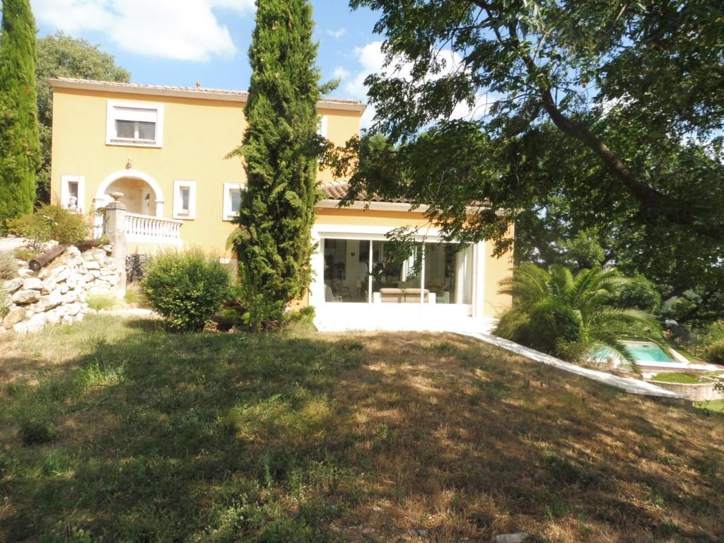 una casa con un gran patio delante de ella en Montèze Paradis, en Saint-Christol-lès-Alès