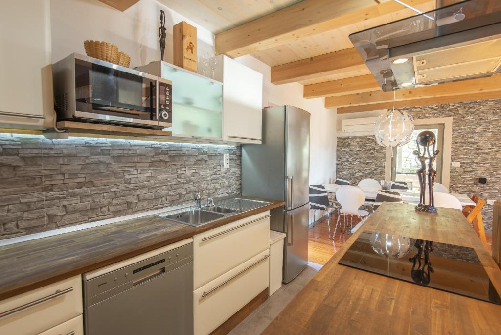 eine Küche mit einer Spüle und einer Mikrowelle in der Unterkunft Holiday Home Casa Salina in Sečovlje