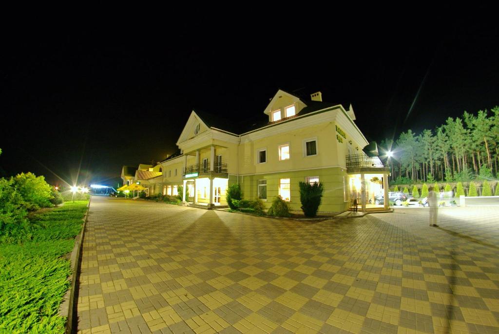 a large white house at night with a cobblestone street at Hotel Mirage in Sudovaya Vishnya