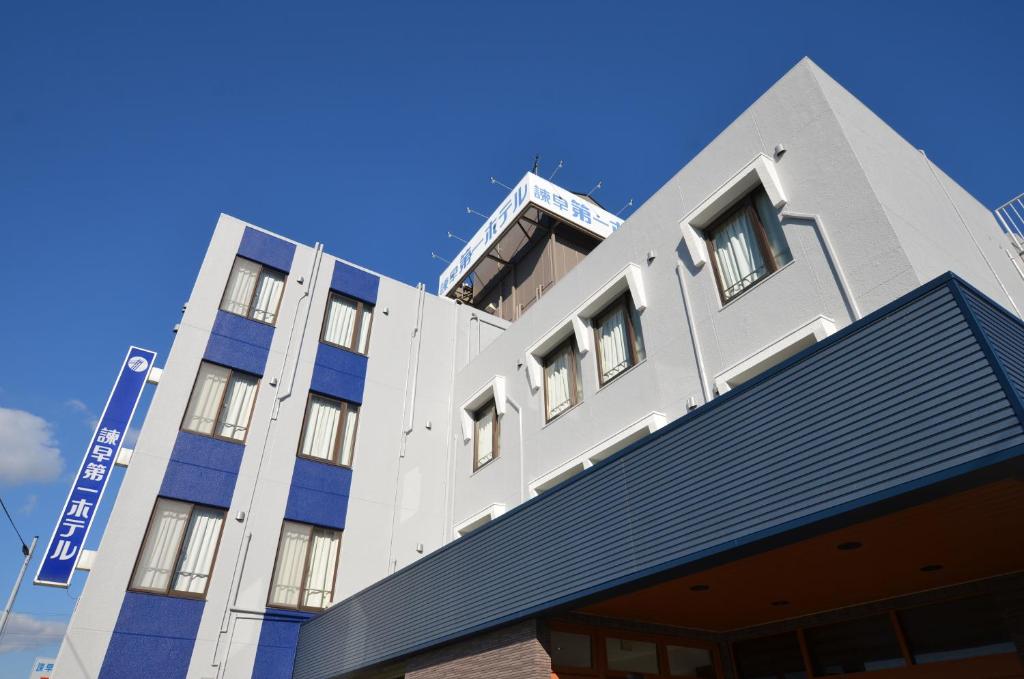 um edifício branco com um telhado azul em Isahaya Daiichi Hotel em Isahaya