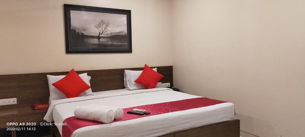 a bedroom with a bed with red and white pillows at Kedari Residency in Yeraoda