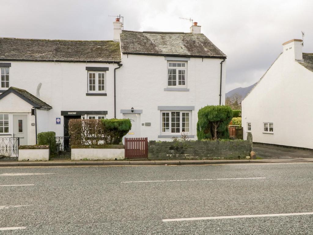 une maison blanche sur le côté d'une rue dans l'établissement Fountain Cottage, à Keswick