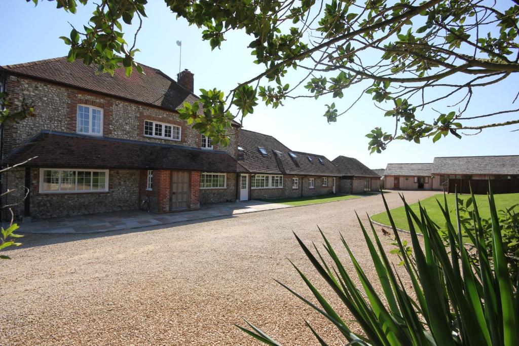 a row of old brick buildings with a driveway at Flintstone Cottages in Chichester